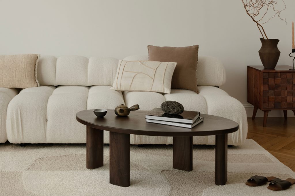 Rugmaker_A serene, minimalist living room with a plush, white sofa adorned with neutral cushions and a cozy blanket