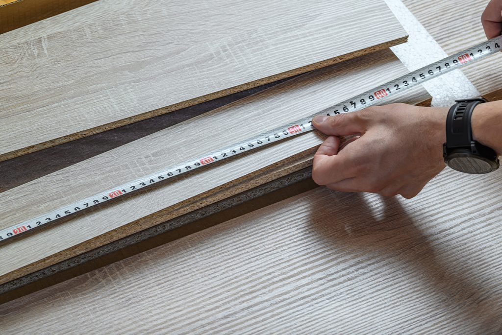 Rugmaker_Man measures chipboard boards in centimeters, custom-made furniture