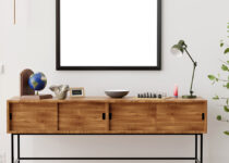 Rugmaker_Blog-Piece-Header_Stylish and eclectic dining room interior with mock up poster map, sharing table design chairs, gold pedant lamp and elegant sofa in second space
