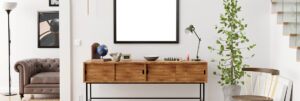Rugmaker_Blog-Piece-Header_Stylish and eclectic dining room interior with mock up poster map, sharing table design chairs, gold pedant lamp and elegant sofa in second space