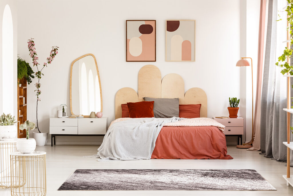Rugmaker_Blog-Piece_Modern posters above bed with headboard in pastel bedroom interior with mirror