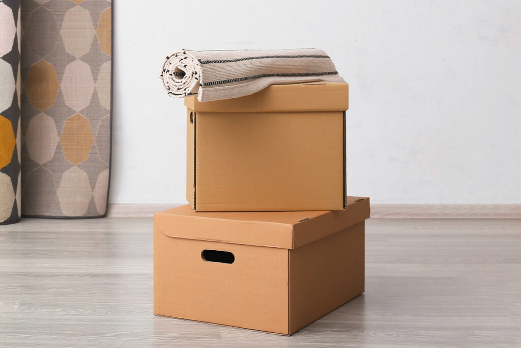Rugmaker_Blog-Piece_Cardboard boxes with rolled carpets in room