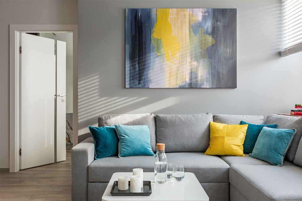 Rugmaker_Blog-Piece_Living room with corner sofa, colorful cushions and white coffee table