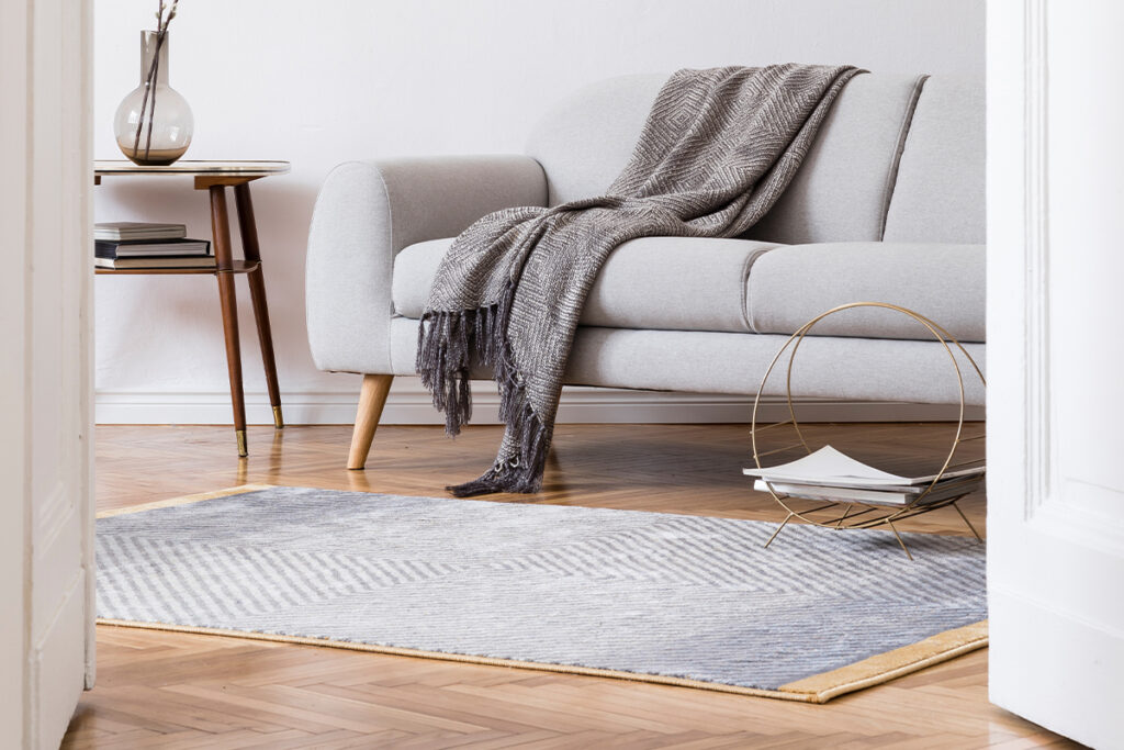 Rugmaker_Blog-Piece_Stylish scandi interior of home space with design grey sofa and retro small table
