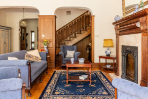 Rugmaker_Blog-Piece_A luxurious living room interior with antique sofa and coffee table in front of a fireplace in an En