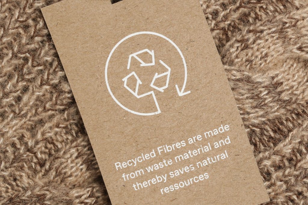 Rugmaker_Blog-Piece_Close up of clothing tag with recycle icon. Recycling products concept