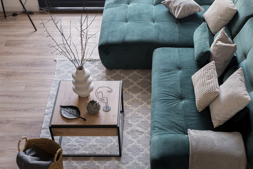 Rugmaker_Blog-Piece_Top view of cozy sofa with pillows and square coffee table with decorations in small living room wit
