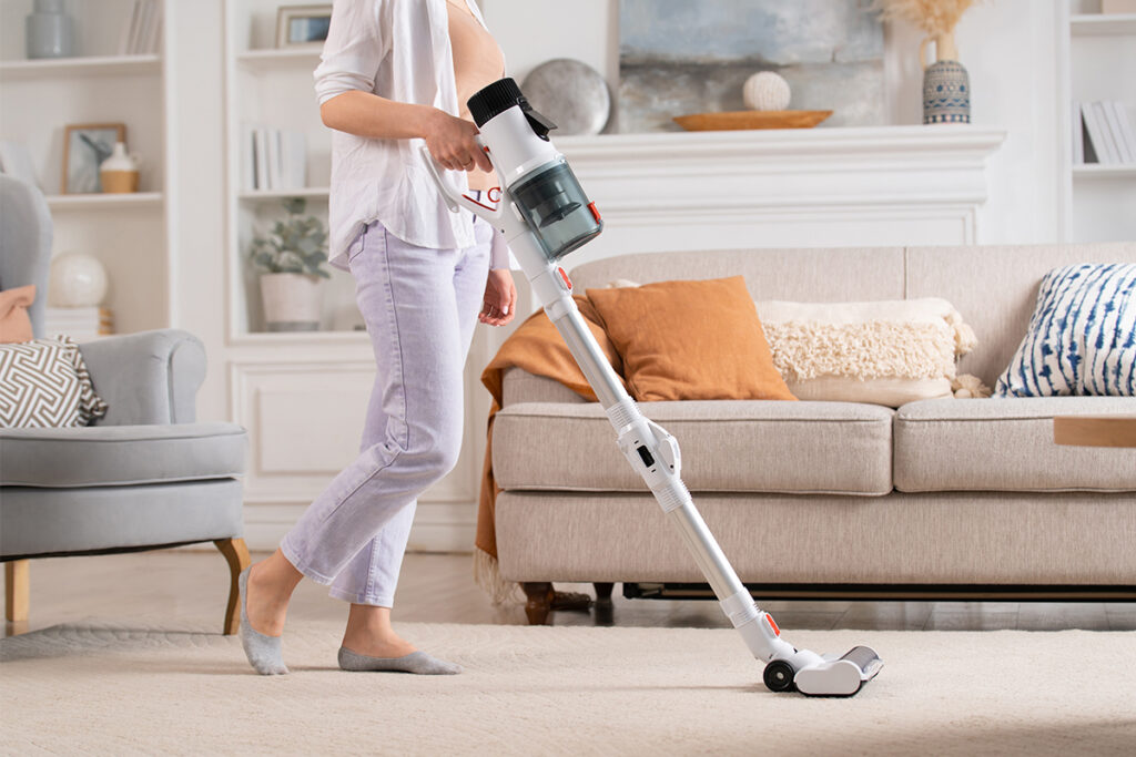 Rugmaker_Blog-Piece_Young woman uses cordless vacuum cleaner to clean home carpet