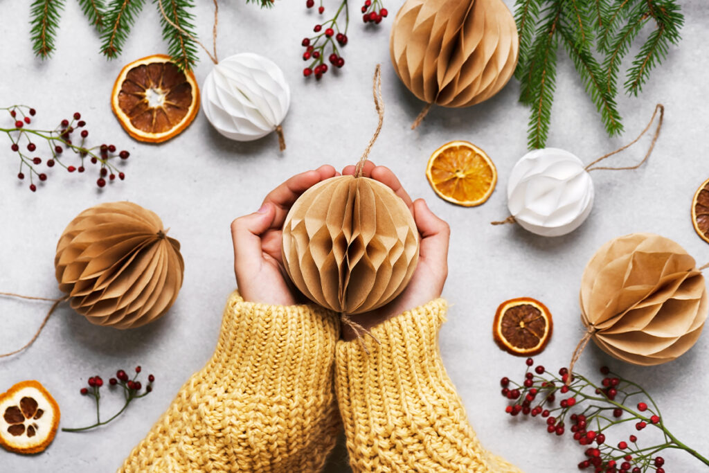 Rugmaker_Blog-Piece_Handmade Christmas Honeycomb ball made from white und brown coffee filter in girl hands