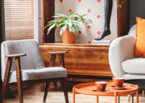 Rugmaker_Blog-Piece_Main Image_Grey armchair next to lamp in orange vintage living room interior with sofa next to cabin