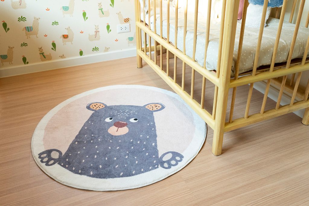 Rugmaker_Blog-Piece_stylish baby room with green walls, comfortable crib and bear dooddle carpet rug.