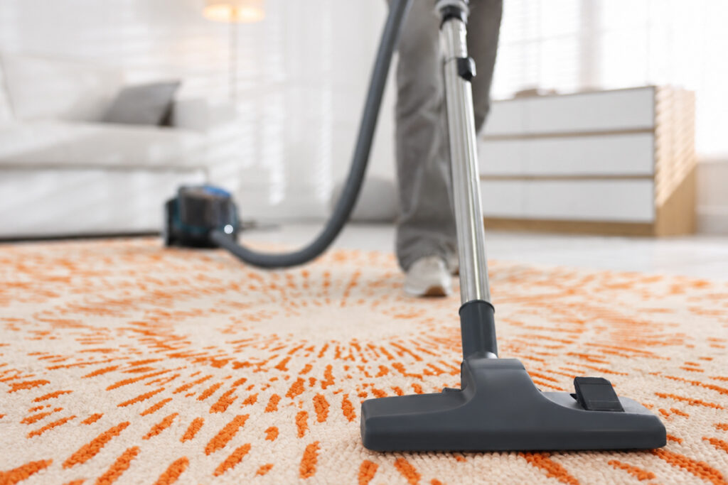 Rugmaker_Blog-Piece_Teenage girl cleaning carpet with vacuum cleaner at home, closeup